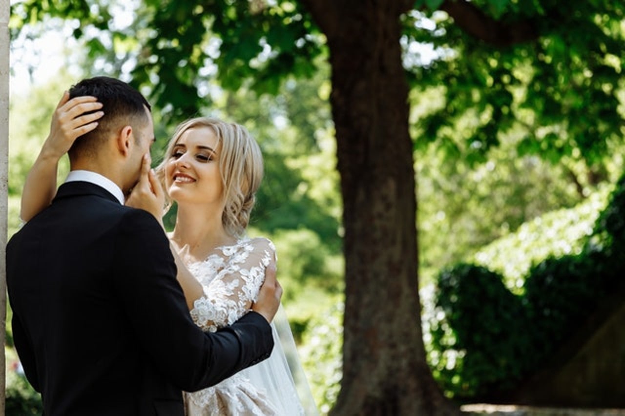 Newlyweds dancing in front of a tree