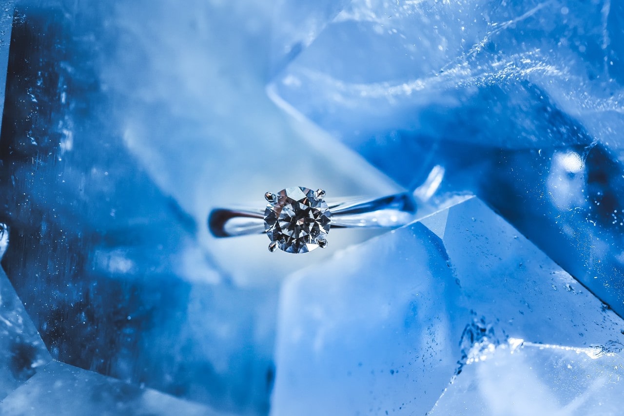 Solitaire engagement ring against an icy background