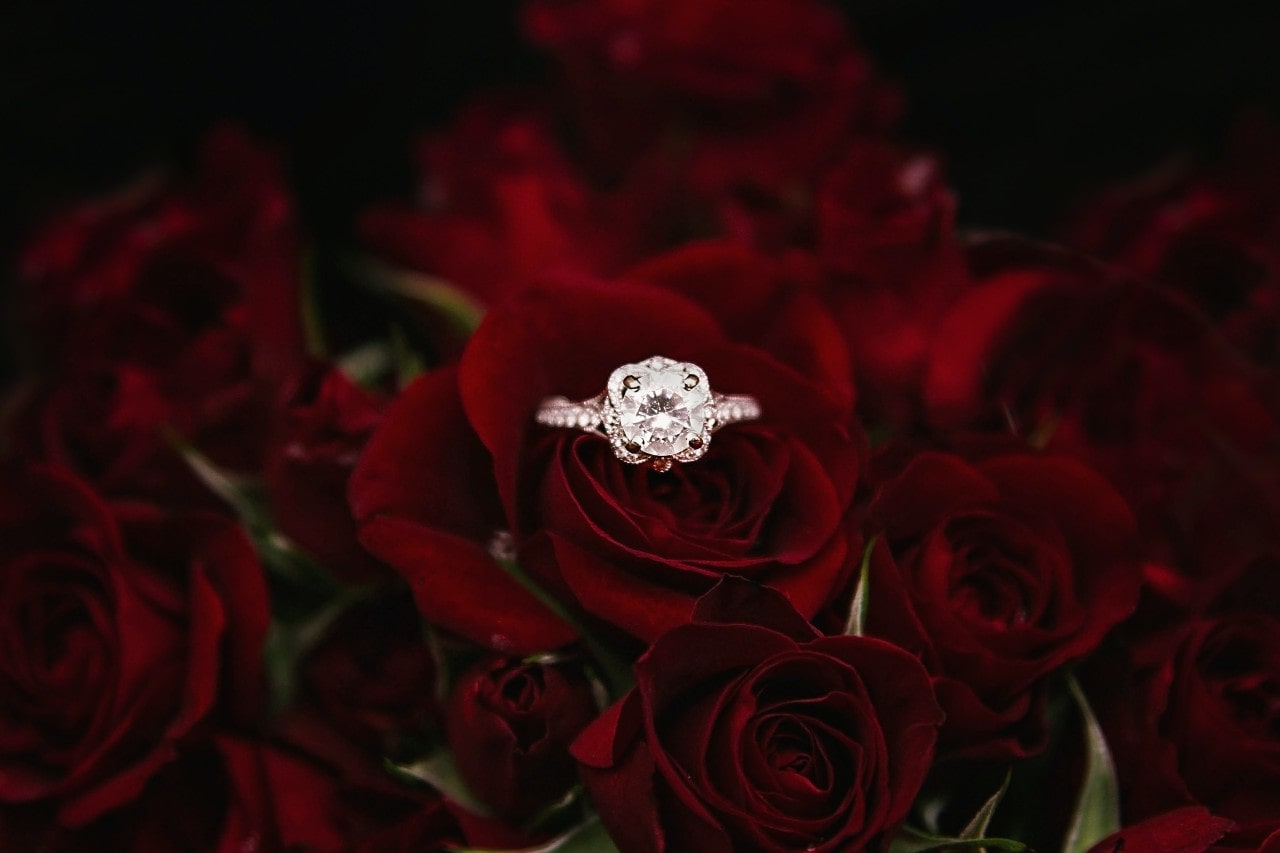 Eccentric and romantic engagement ring resting on a bed of roses