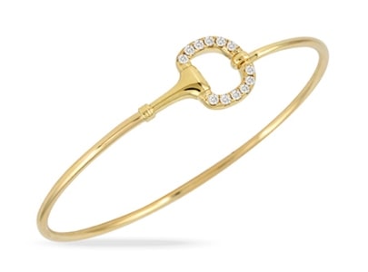 A dainty yellow-gold bangle modeled after a horse snaffle bit