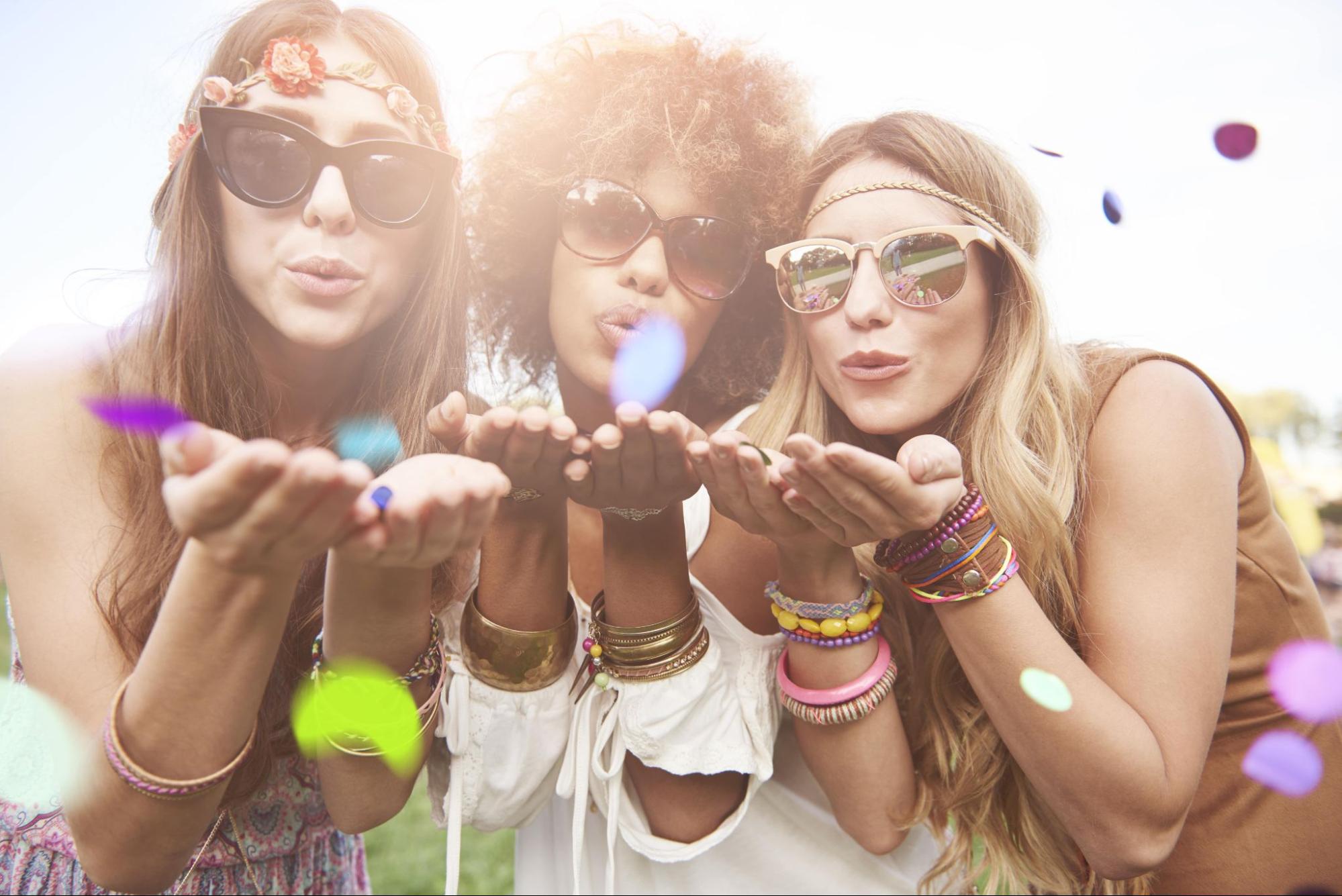 Three women wearing sunglasses and jewelry in the sun