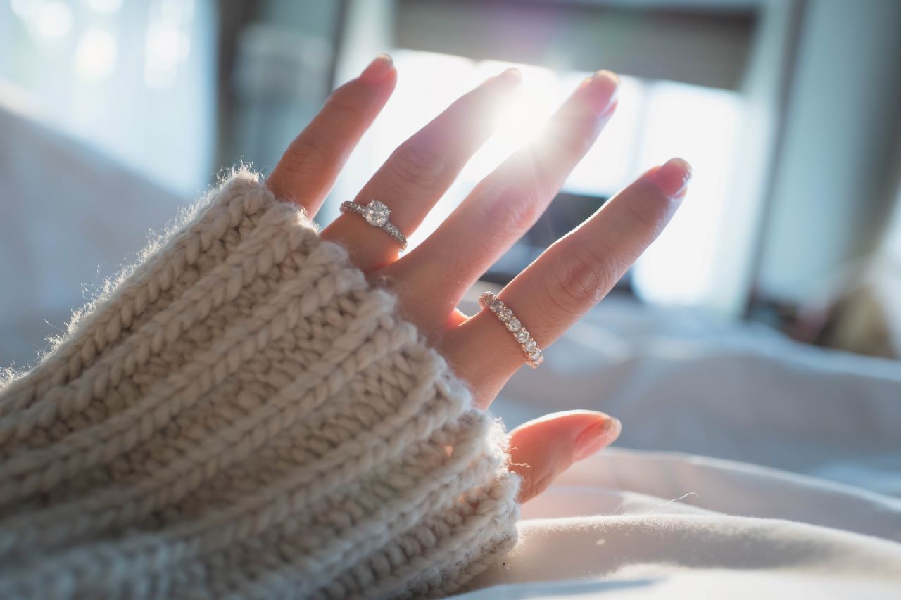 A woman’s hand wearing diamond rings