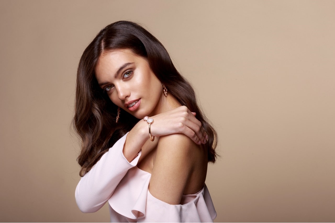 fashionable lady wearing casual jewelry staples with a beige background