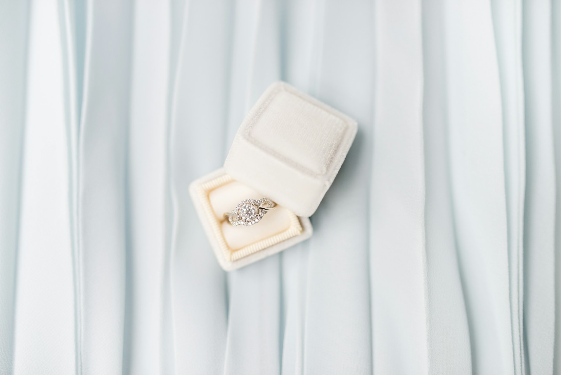 An elegant engagement ring displayed in a simple white box.