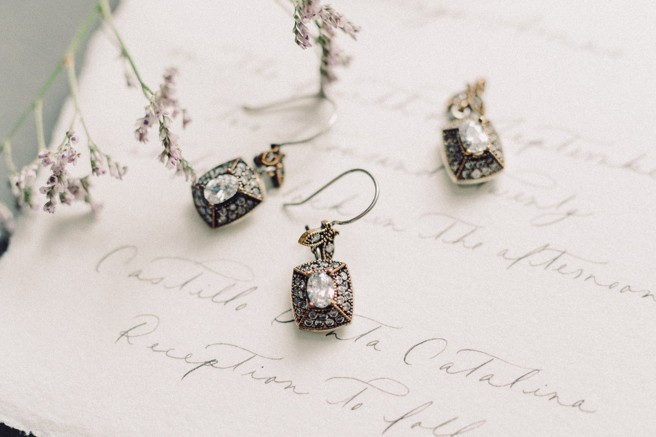 Close-up of antique drop diamond earrings placed on a vintage letter. Close-up of antique drop diamond earrings placed on a vintage letter.