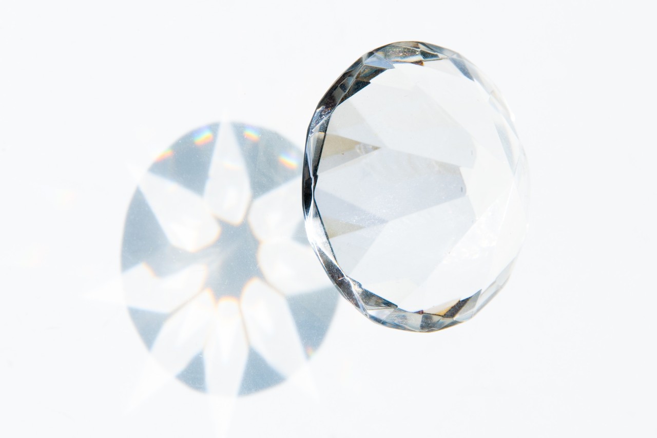 close up image of a round cut diamond and its geometric shadow