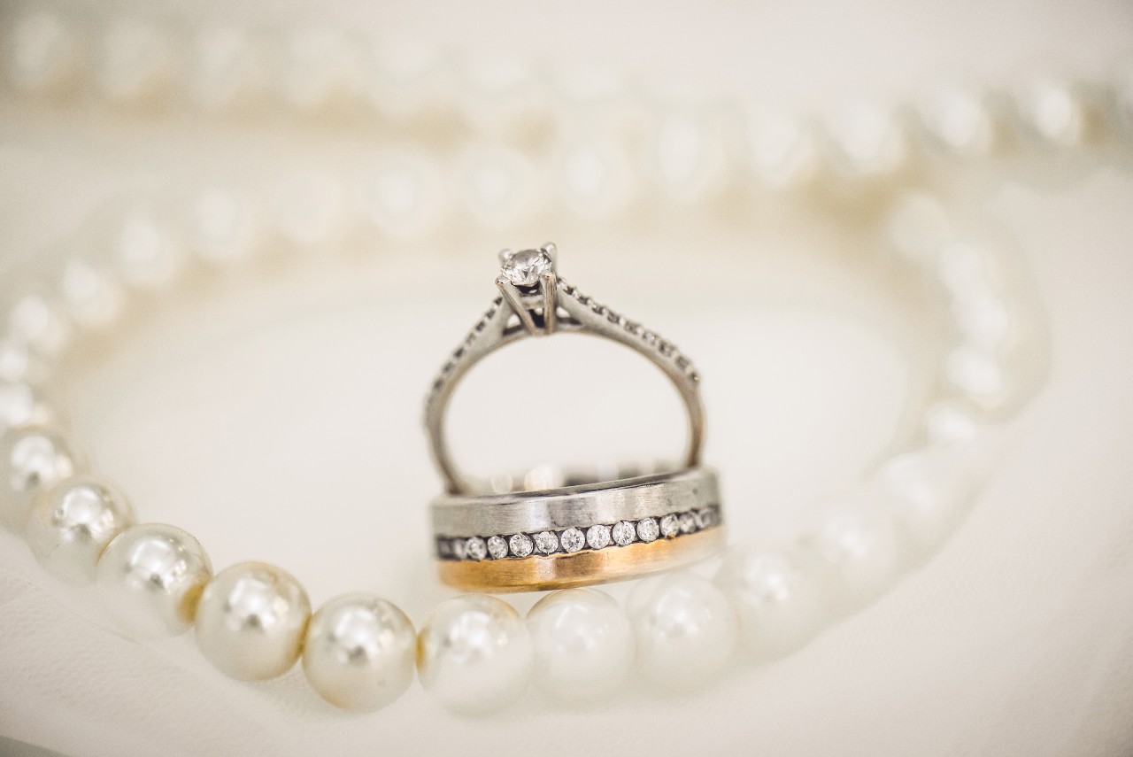 a matching engagement ring and wedding band set with diamonds surrounded by pearls