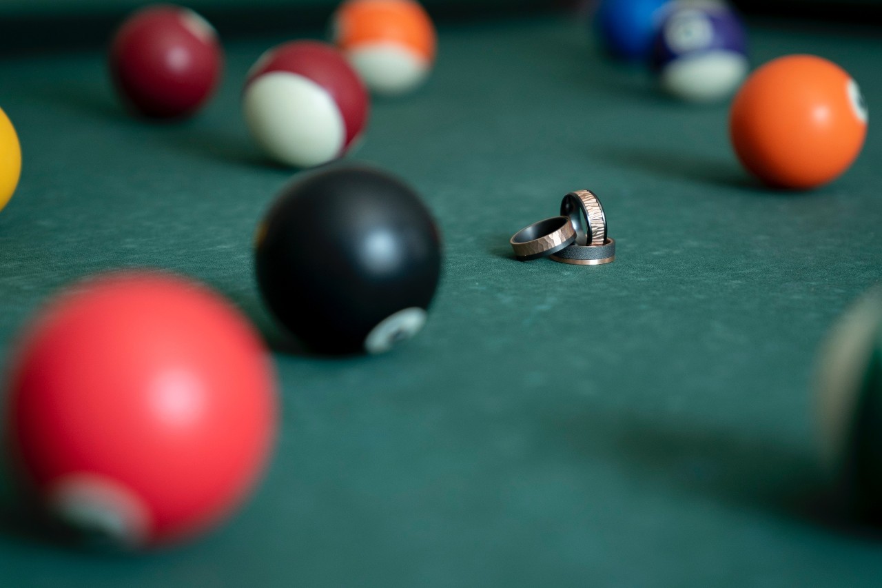 unique wedding bands on a pool table