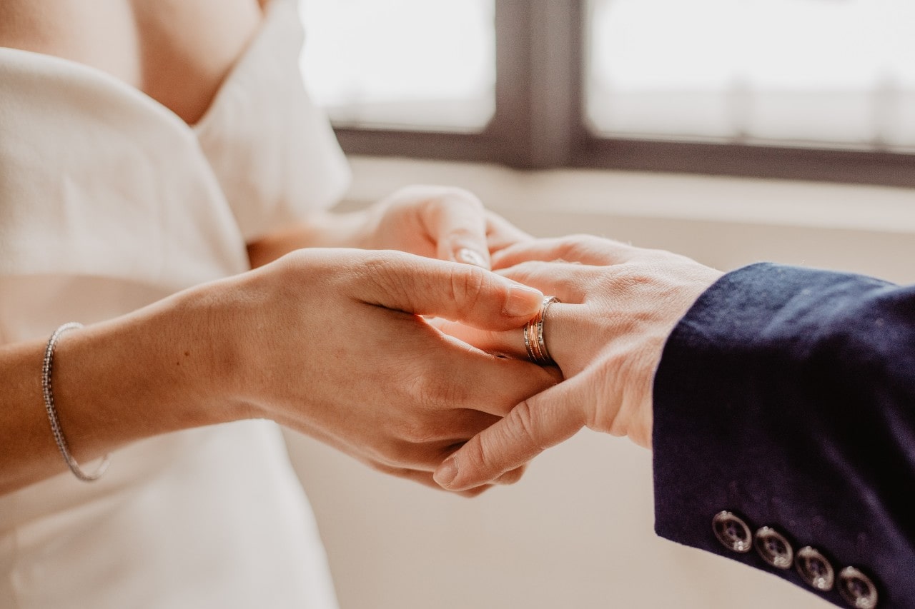 wedding bands being placed on hand