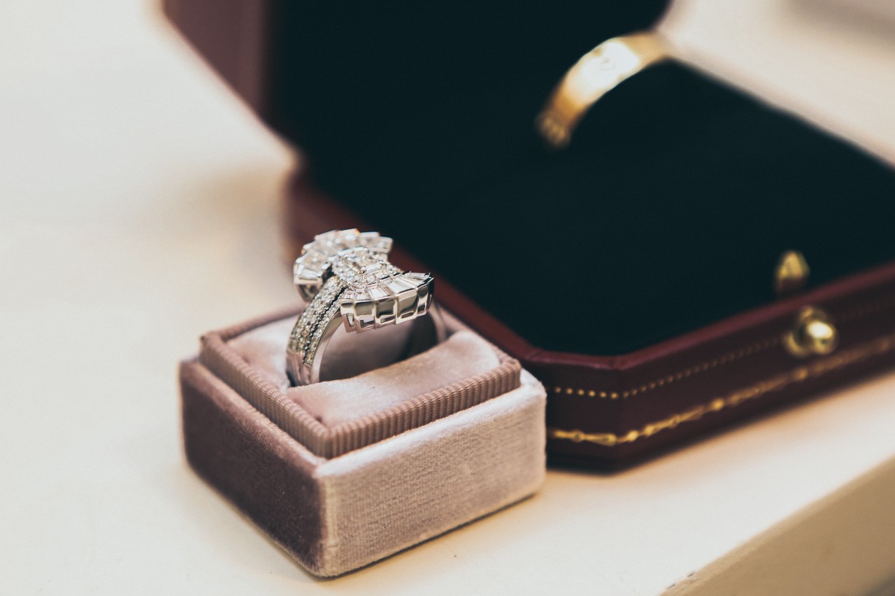 an Art deco inspired halo ring in a pink box.