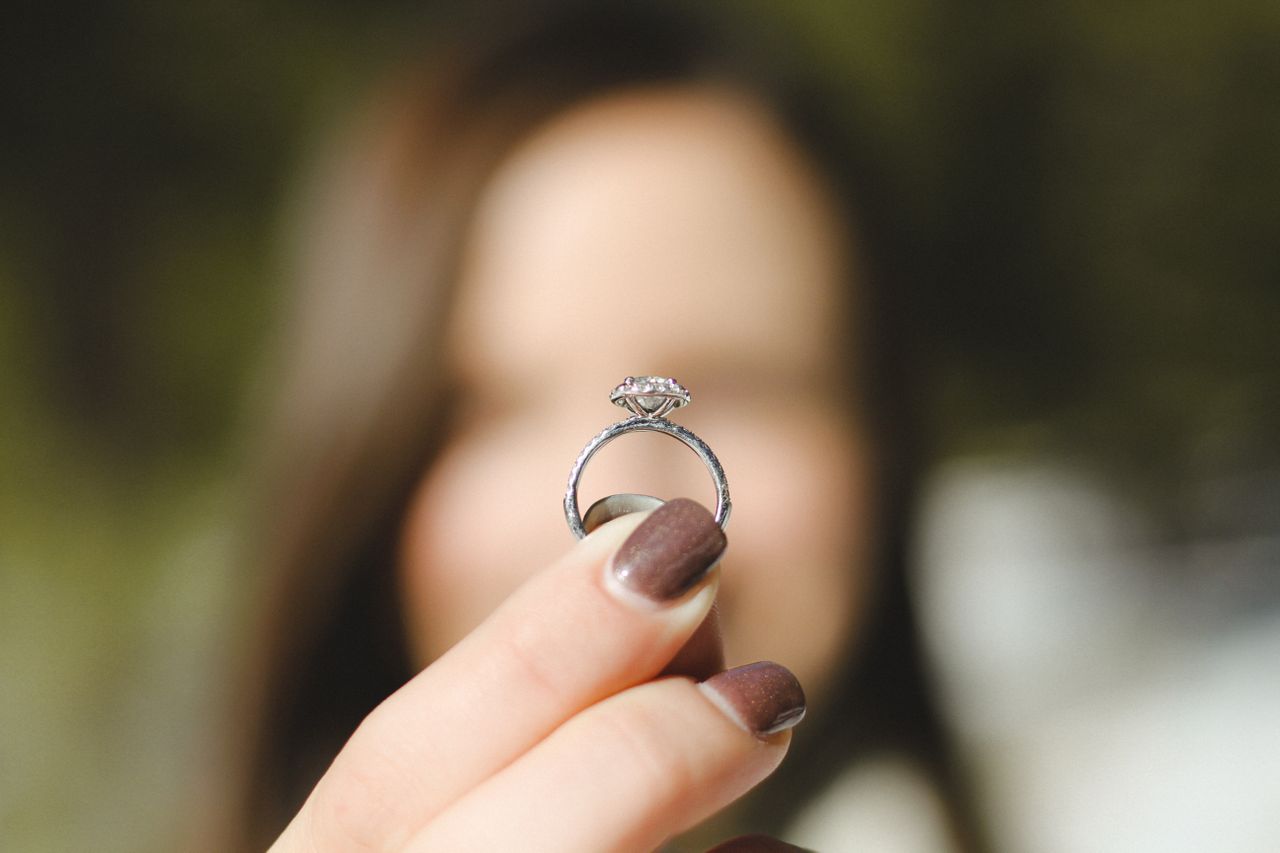 a woman holds an engagement ring.