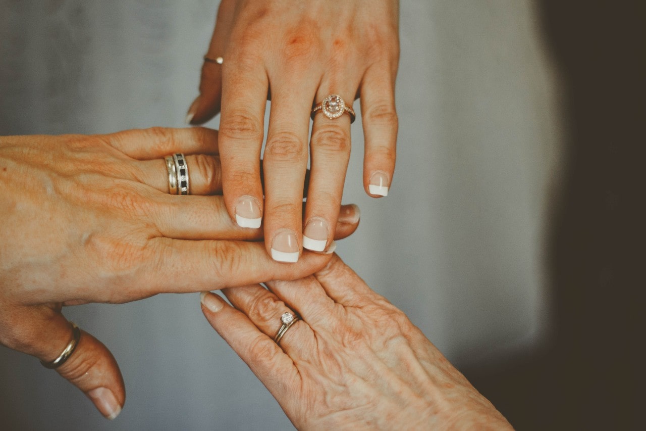 a trio of older women wearing vintage engagement rings.